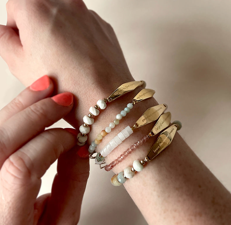 A model wearing Presently's Gold Gemstone Bracelet Collection, showcasing bracelets designed to support mental wellness and encourage mindfulness, engraved with empowering phrases for anxiety and OCD.