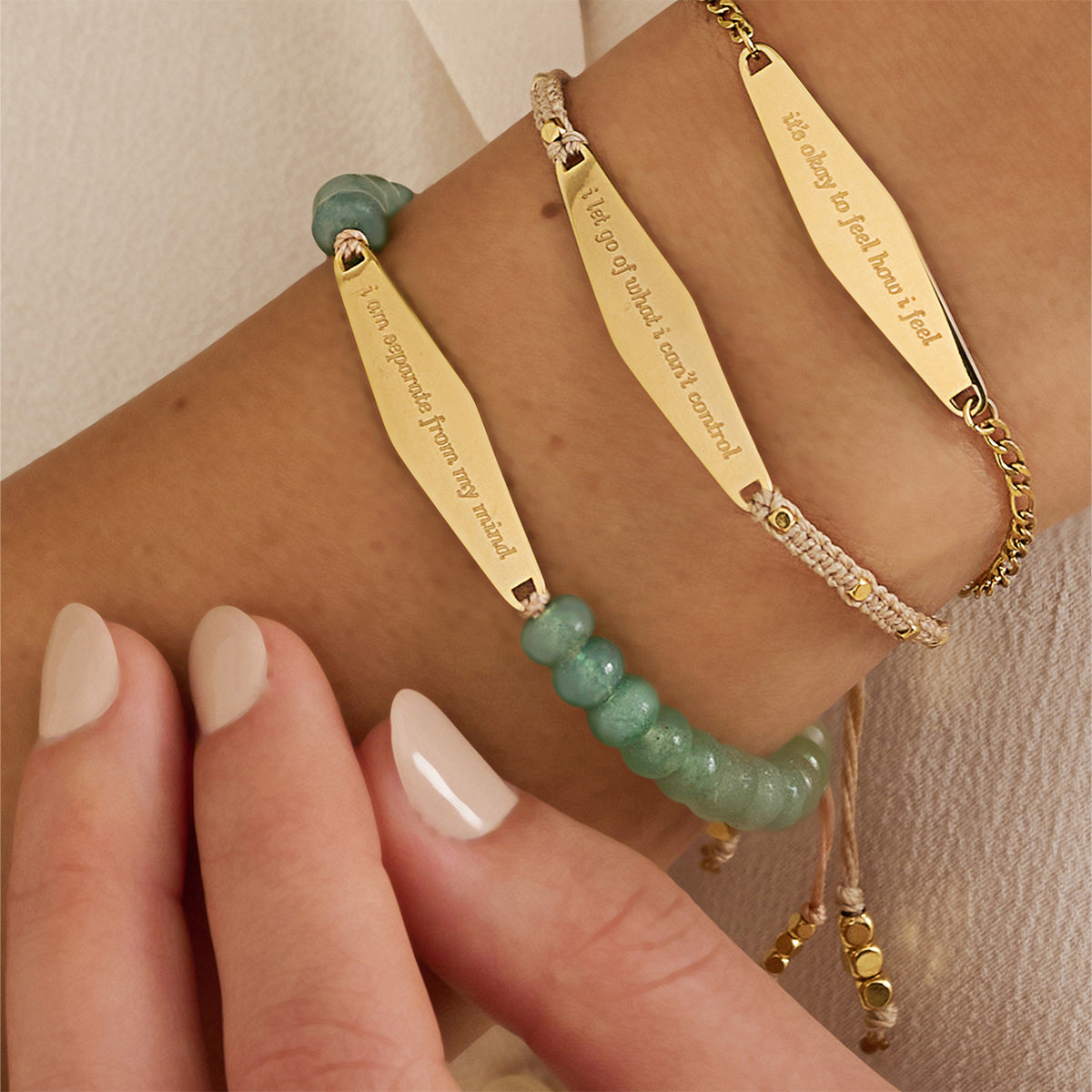 Close-up of a model wearing three bracelets from Presently's Mindfulness Collection, each engraved with empowering phrases to support mental wellness and manage anxiety.