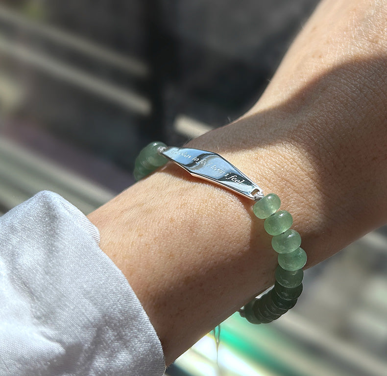 A customer wearing silver aventurine jade bracelet engraved with the phrase