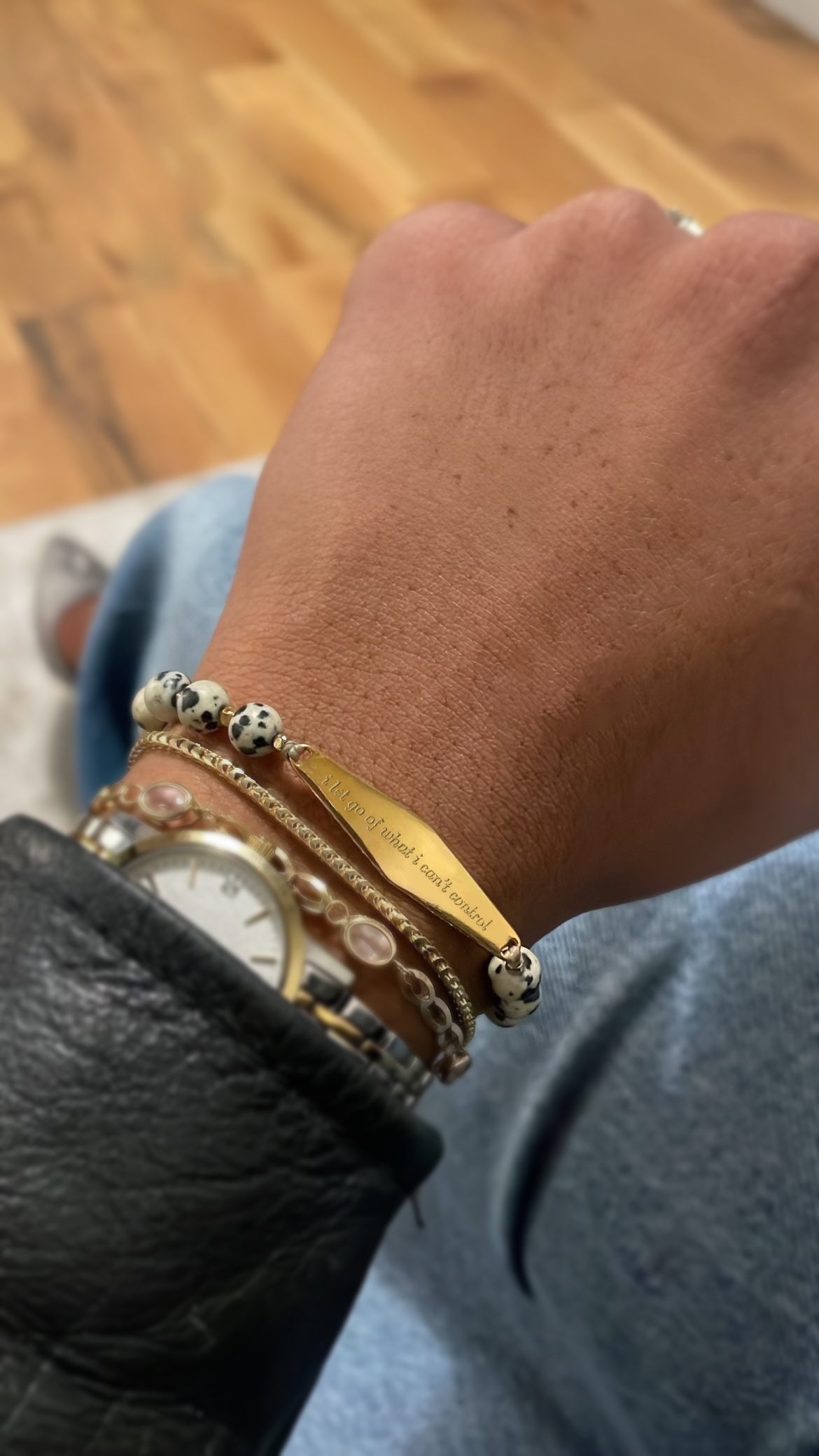 Customer wearing a Gold Dalmatian Gemstone Bracelet, featuring engraved reminder for anxiety and OCD support.