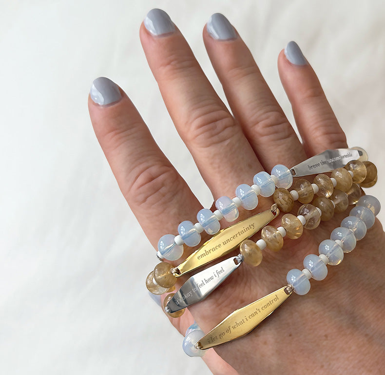 Model holding Opal Gemstone Bracelets alongside other gemstone bracelets.