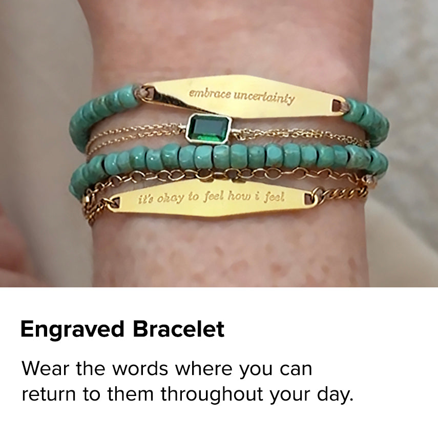 Engraved Bracelet. Gold “Embrace Uncertainty” and “It’s Okay to Feel How I Feel” bracelets layered with turquoise bracelets. Wear the words where you can return to them throughout your day.