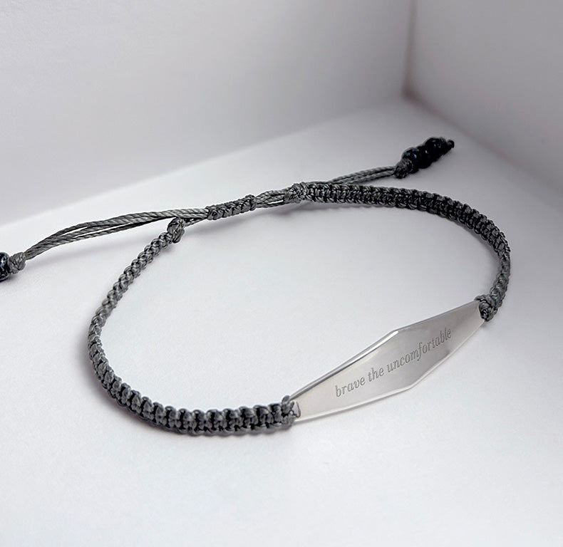 lose-up of Presently's men's charcoal macrame bracelet, engraved with an empowering phrase for anxiety and OCD support.