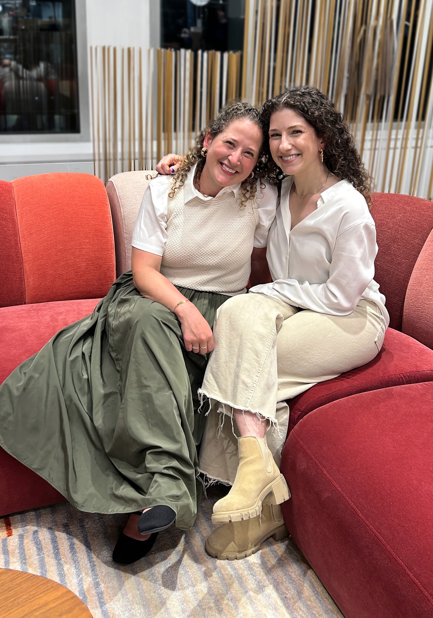 Presently co-founders and sisters, Lindsay and Emily, sitting together and smiling