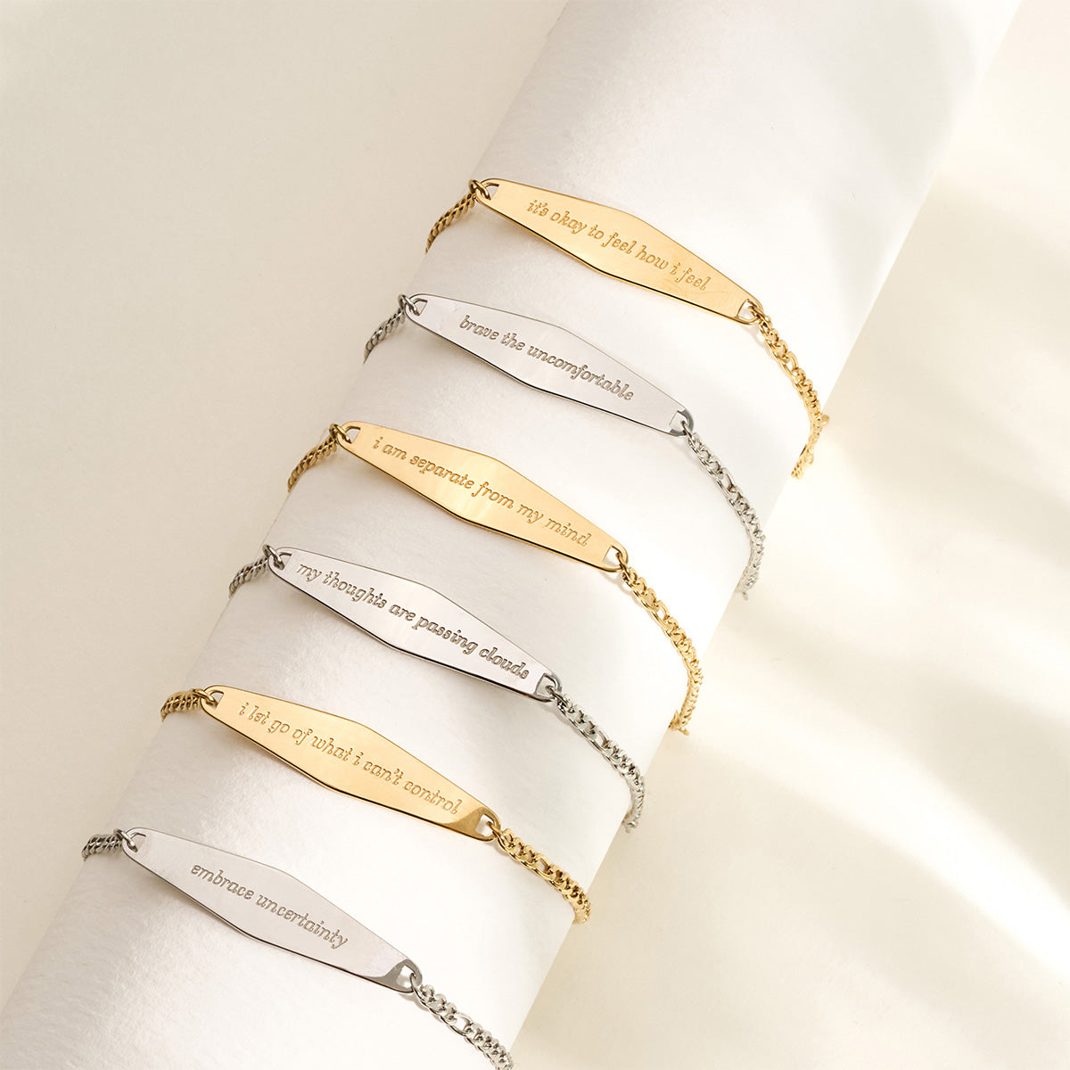 A beautifully arranged display of six Presently Figaro Chain Bracelets in both gold and silver, showcasing their variety and engraved messages.