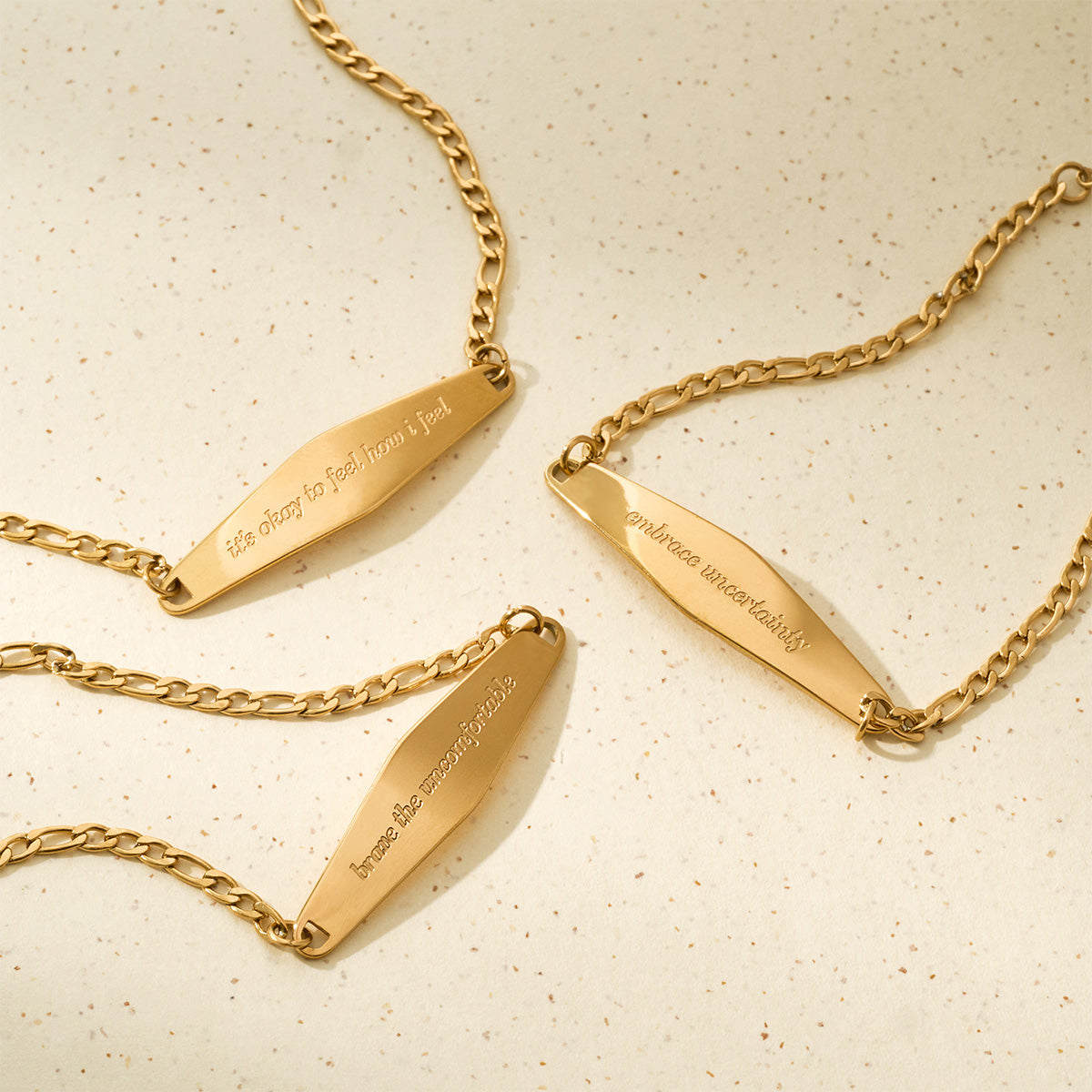 A close-up of three Presently bracelets designed for anxiety and OCD, each featuring an engraved phrase to support mental well-being.