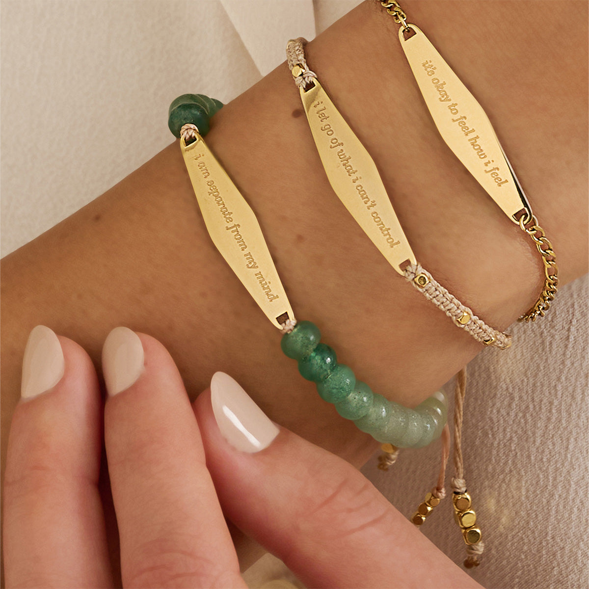 Close-up of a model wearing three bracelets from Presently's Mindfulness Collection, each engraved with empowering phrases to support mental wellness and manage anxiety.