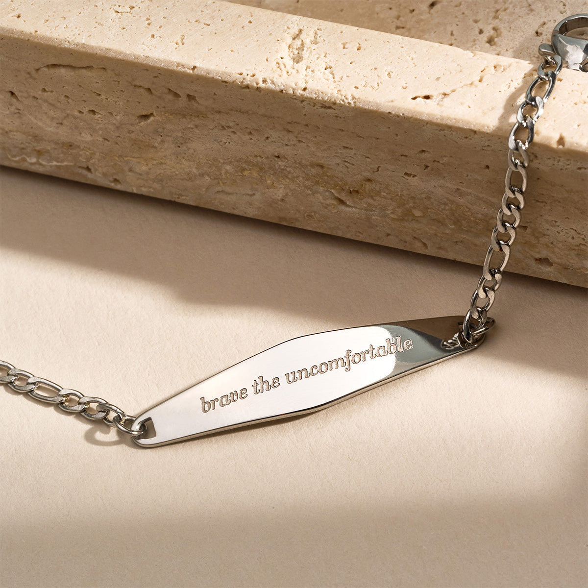 A silver Figaro Chain Bracelet featuring the engraved phrase 