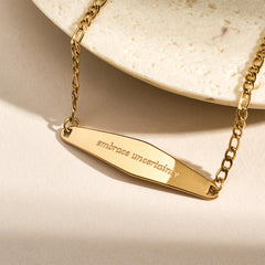 A model stacking three gold Figaro Chain Bracelets, creating a layered and stylish bracelet look.