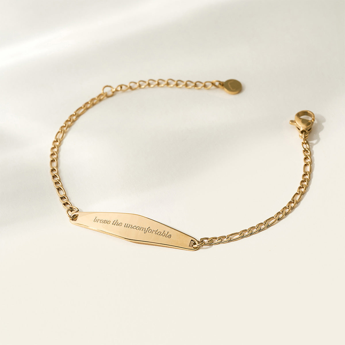 A gold Figaro Chain Bracelet with the engraved phrase 