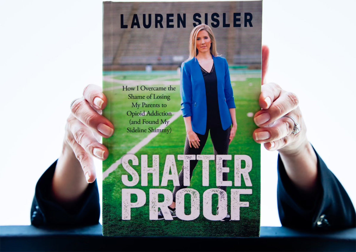 Lauren Sisler, ESPN reporter, holding her book Shatterproof, featuring her journey of overcoming personal challenges and embracing resilience.