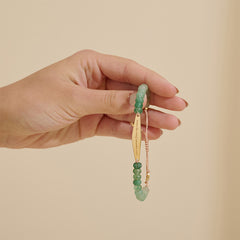 Model holding an Aventurine jade gemstone bracelet engraved with the phrase "I am separate from my mind," part of Presently's collection for anxiety and OCD support.