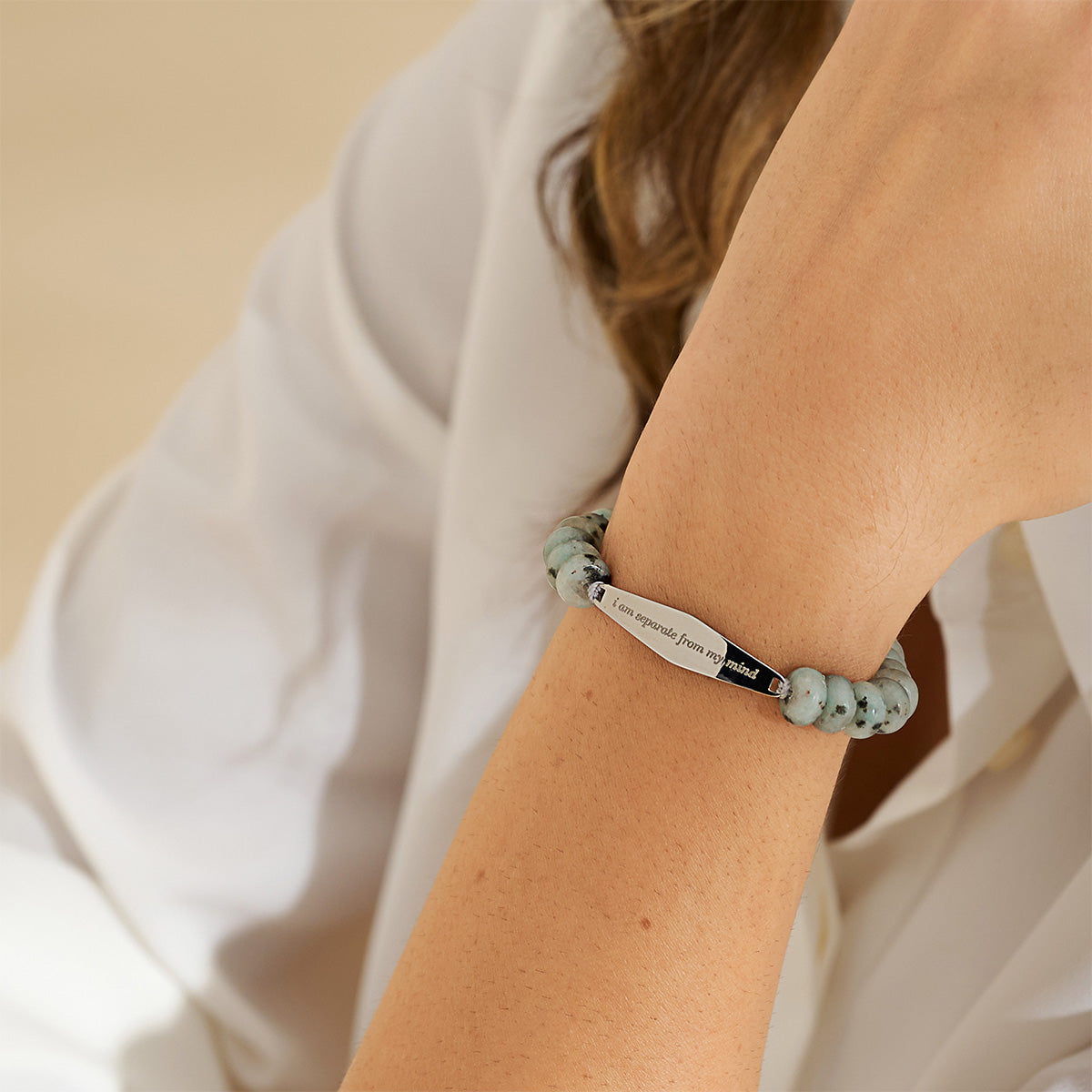 A model wearing a silver Tianshan jade gemstone bracelet engraved with the phrase 