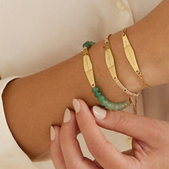 Model wearing three bracelets from Presently's Mindfulness Collection, each engraved with empowering phrases to support mental wellness and manage anxiety.