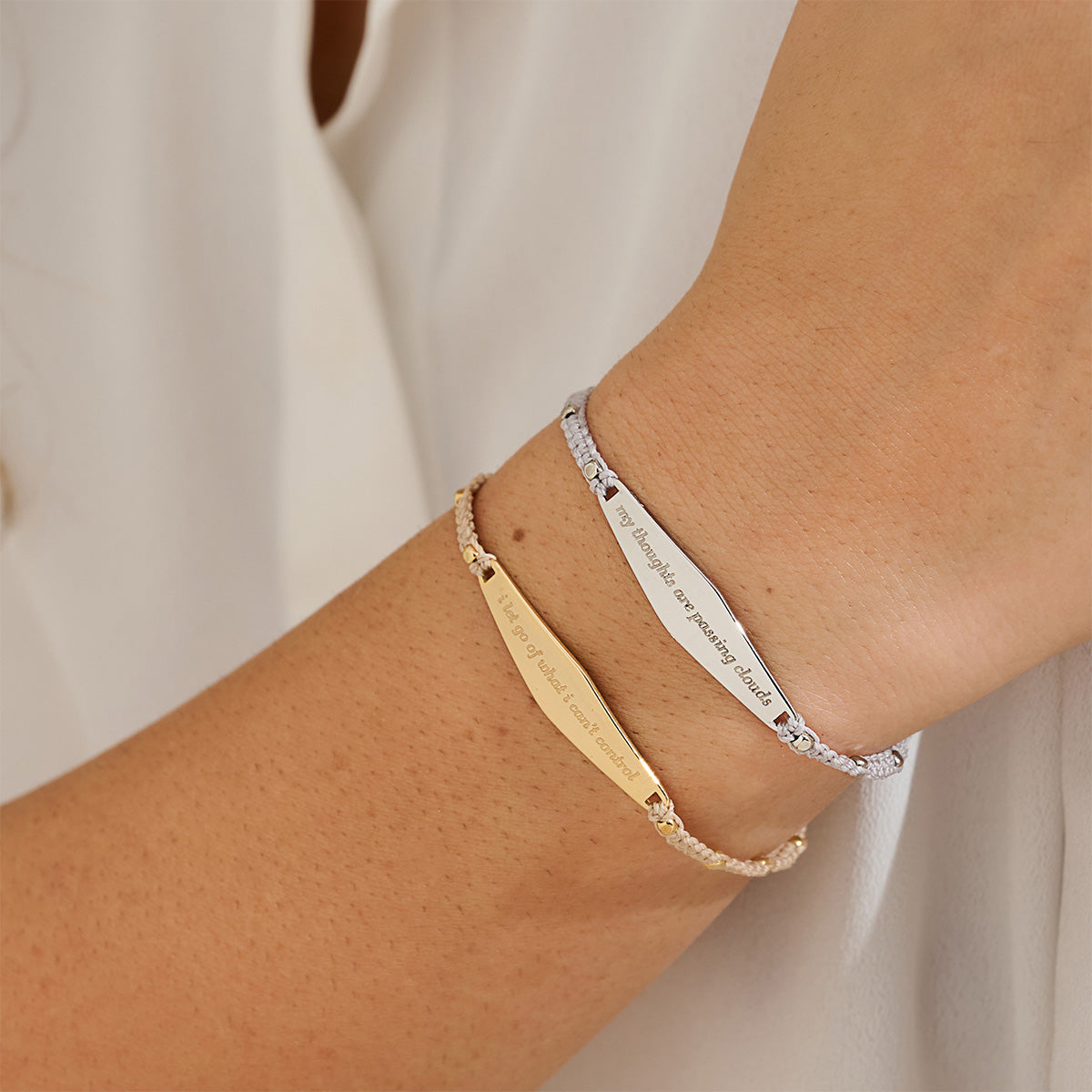 Model wears two Presently Macrame Bracelets in gold and silver, each engraved with a grounding reminder for anxiety and OCD.