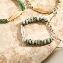 A silver Tianshan jade gemstone bracelet displayed alongside other Presently gemstone bracelets, showcasing the variety of styles designed to support individuals managing OCD and anxiety.