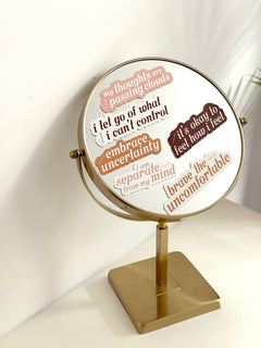Decorative mirror with motivational phrases on a white background