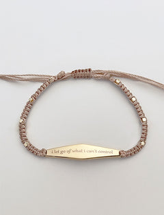 Gold Macrame Bracelet with the phrase "i let go of what i can't control"