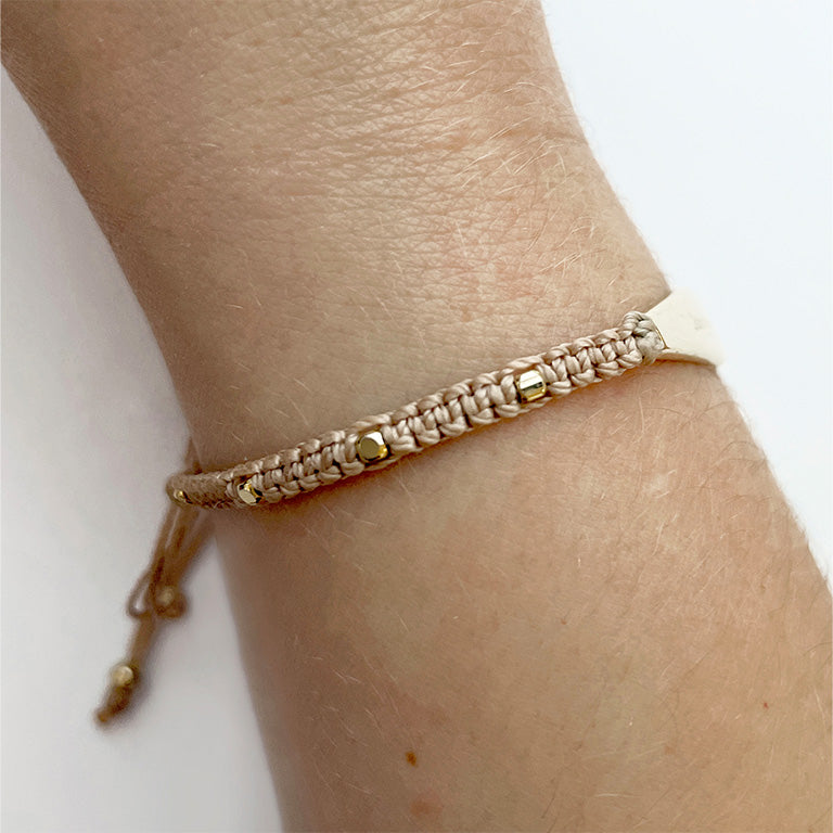 Woman wearing gold macrame bracelet for anxiety