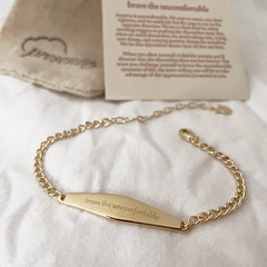 Gold Curb chain bracelet engraved with the phrase "Brave the uncomfortable"