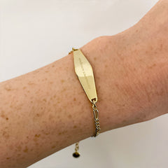 Gold Figaro Chain Bracelet engraved with the phrase "embrace uncertainty"